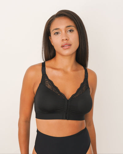 Woman wearing a black bikini set against a white background