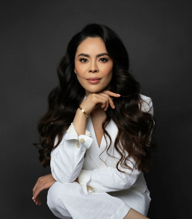 Woman in a white outfit posing against a dark background