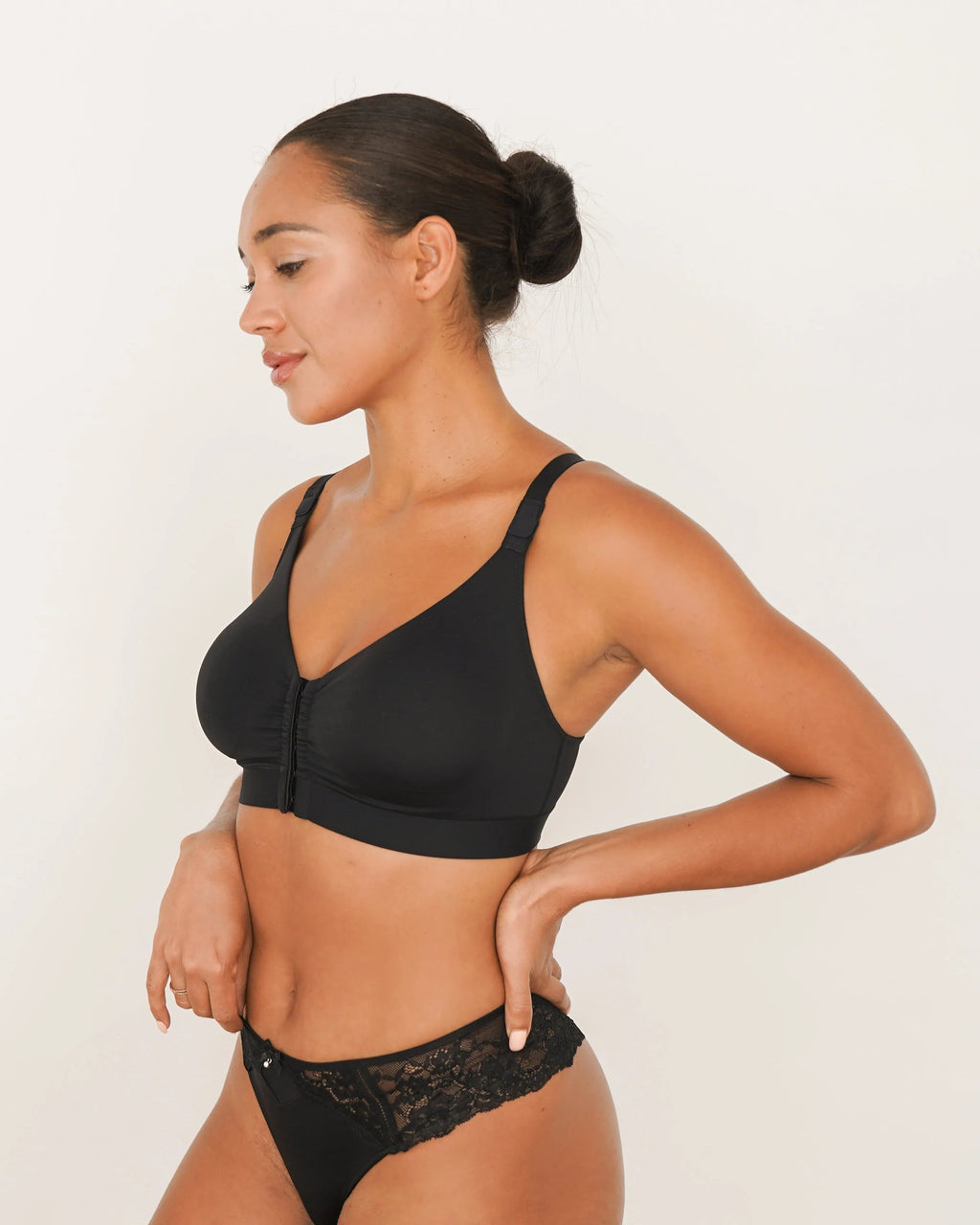 Woman wearing a black bra and panties set on a white background