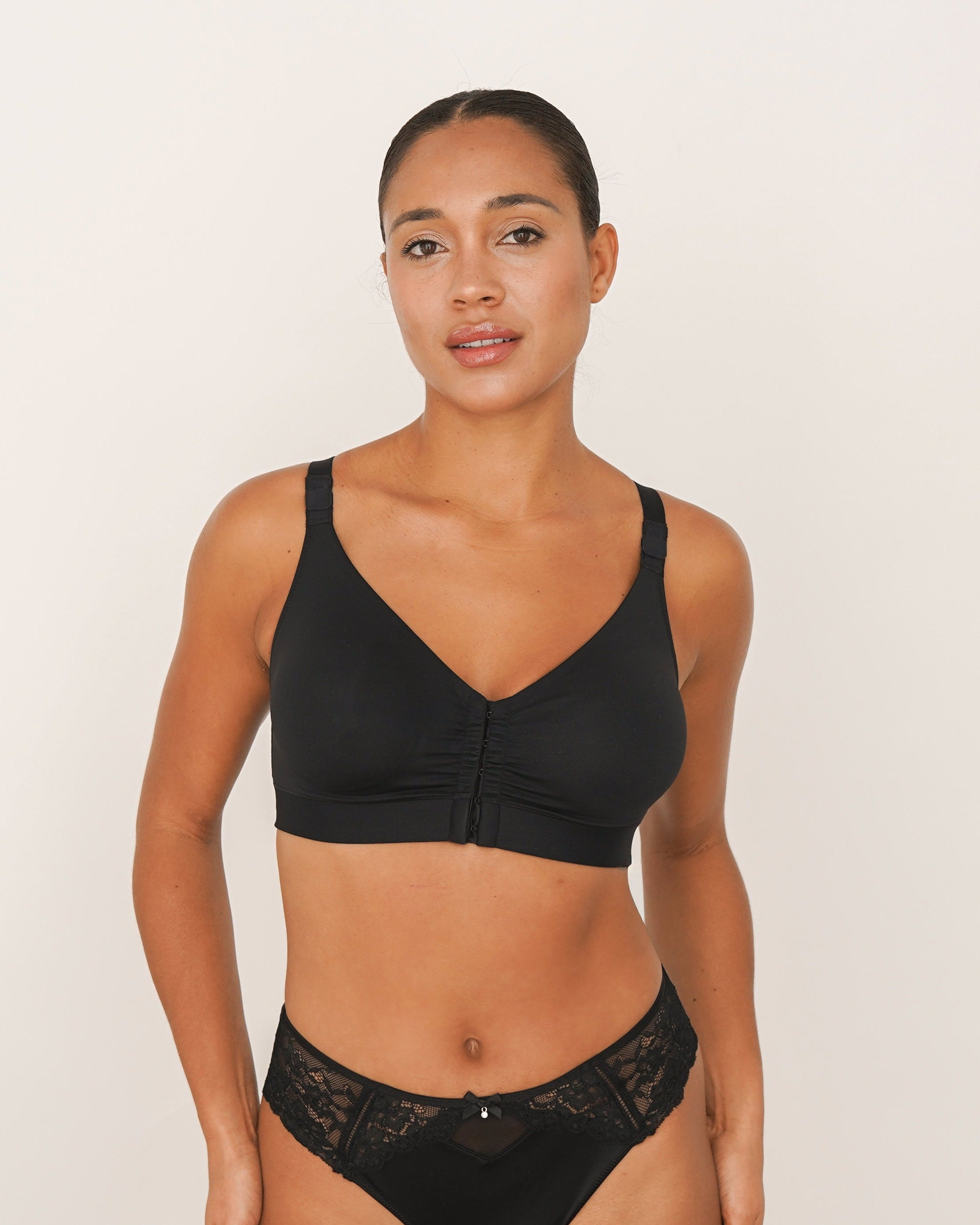 Woman wearing a black bikini set on a plain background