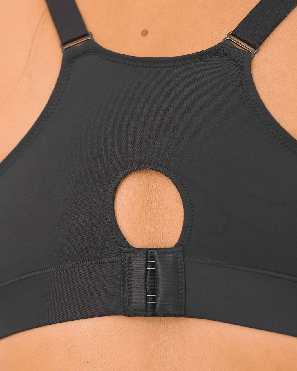 Black sports compression bra with a keyhold and angled shoulder straps on a white background