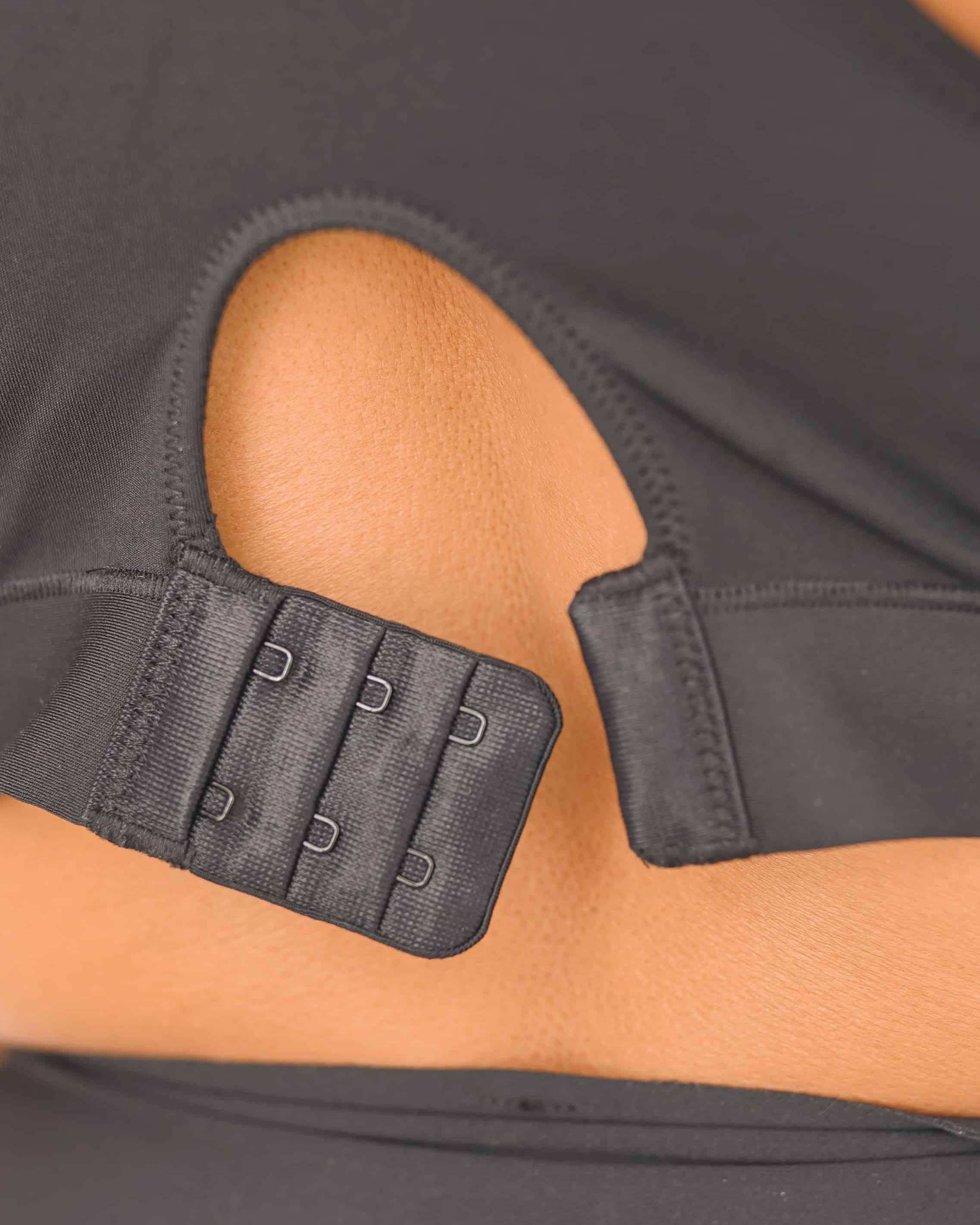 Person wearing a black sports bra and leggings on a white background