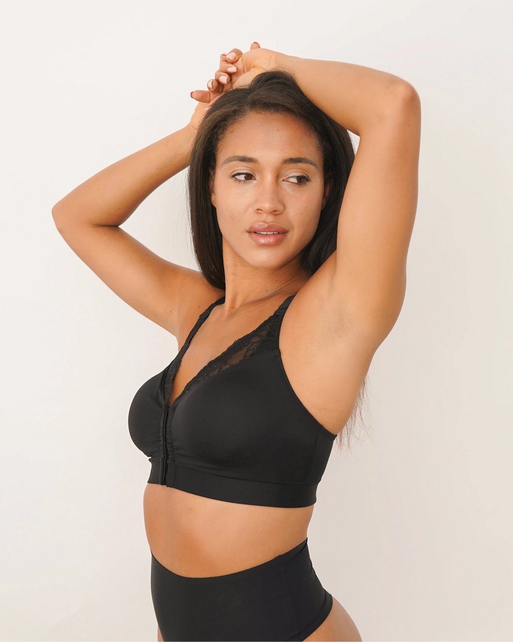 black lace surgical bra arms up white background