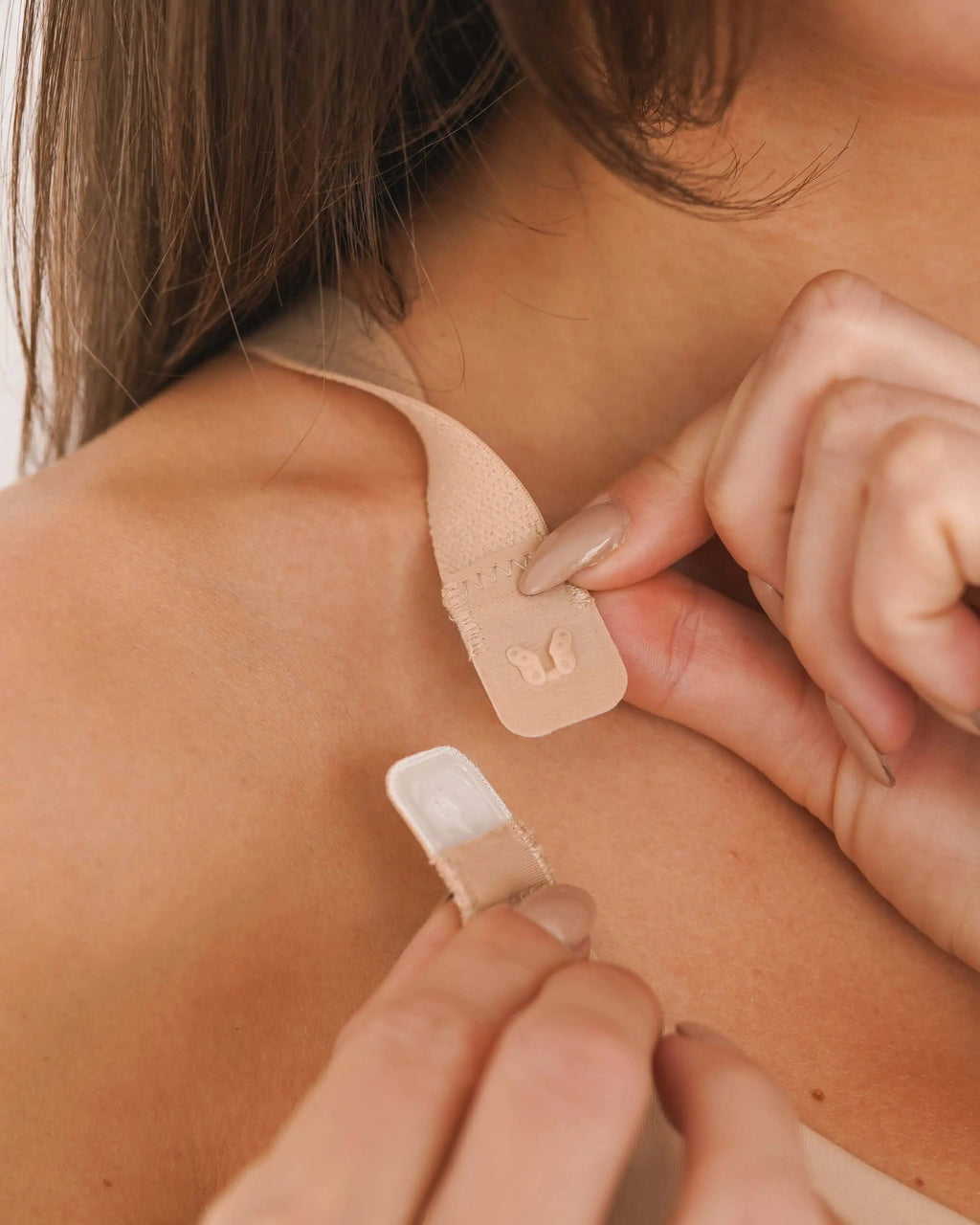 Adjustable shoulder strap closure on nude non lace post surgical compression bra showing hook and tab fastening